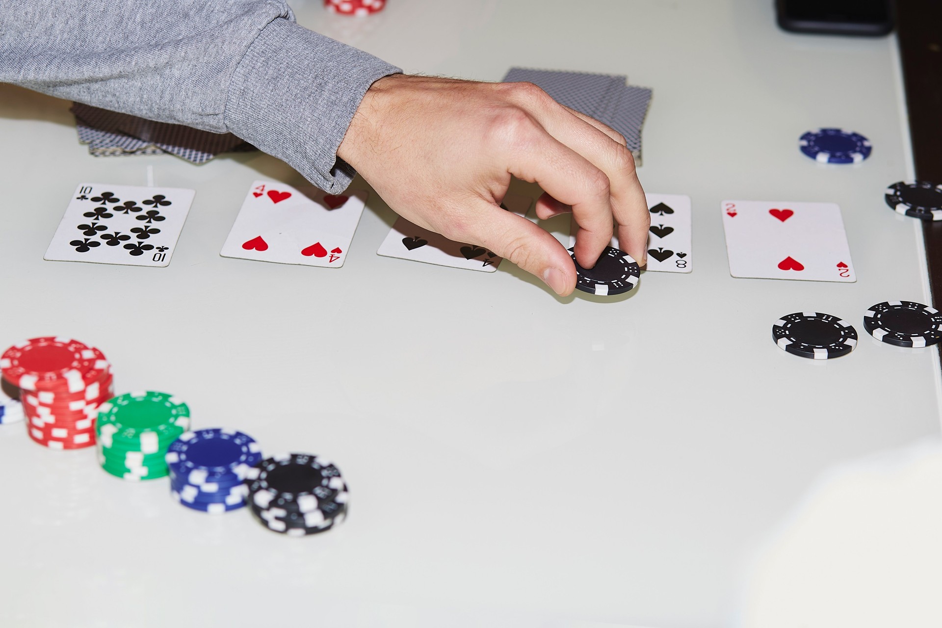 Laying out cards on the table in poker game. Player making a stroke. Gambling concept. Candid moment. Poker background lifestyle photography. Selective focus